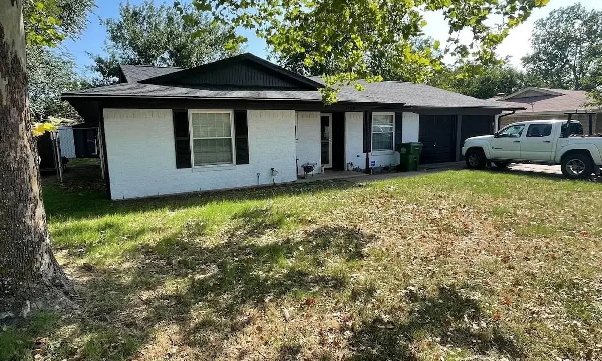 Professional roofing crew working on a residential roof in Sudley